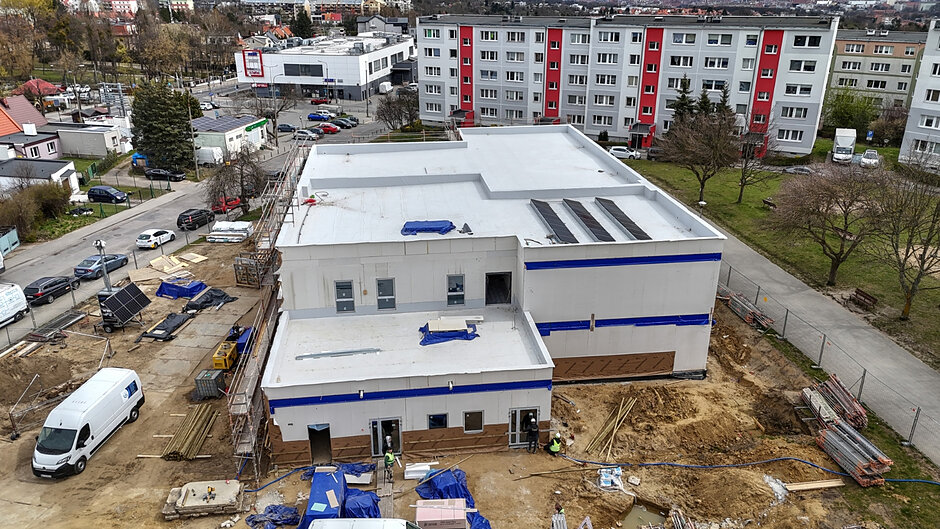 zdjęcie z drona na budowę nowego budynku żłobka, w tle bloki mieszkalne