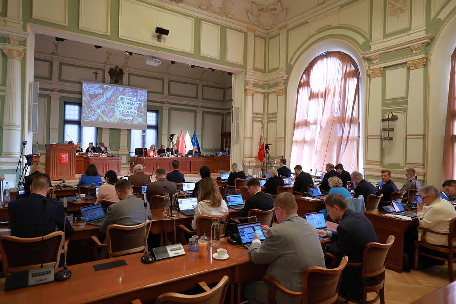 Sesja Rady Miasta. Radni siedzą podczas obrad i głosują