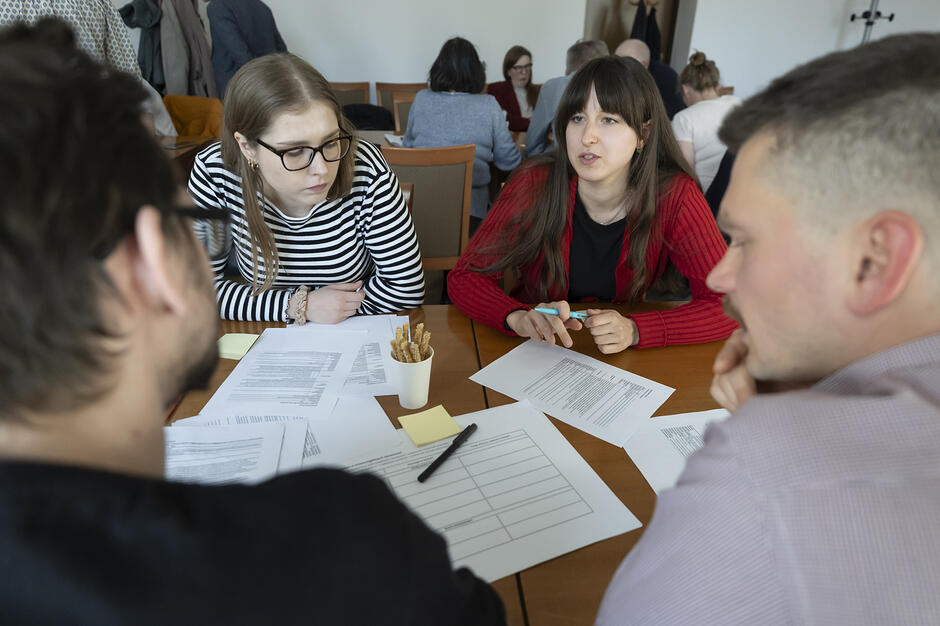 grupa osób dyskutuje przy stole