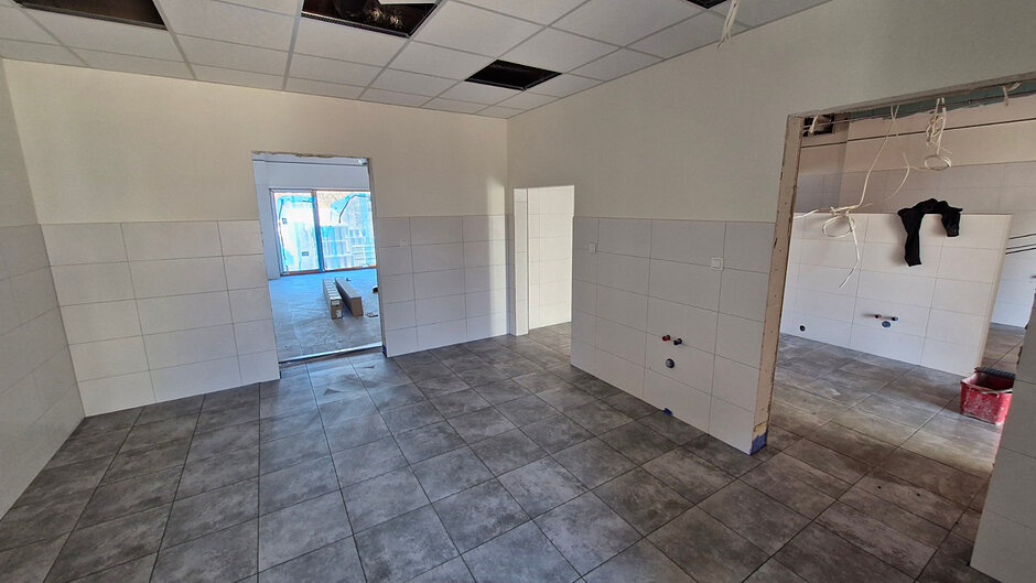 wnętrze budowanego budynku, są białe ściany z jasnymi kafelkami 