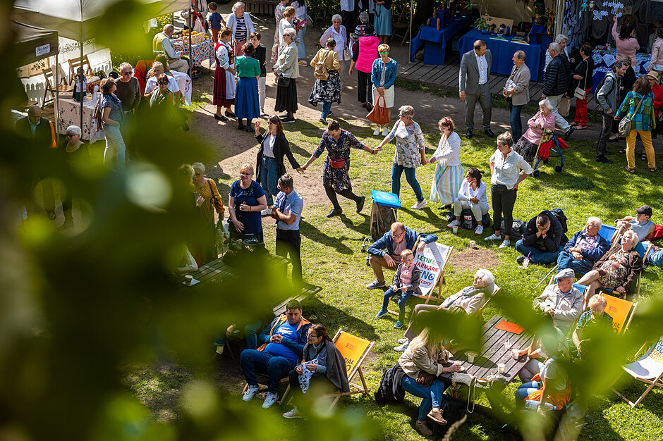 Ludzie bawią się na jarmarku w otoczeniu przyrody 