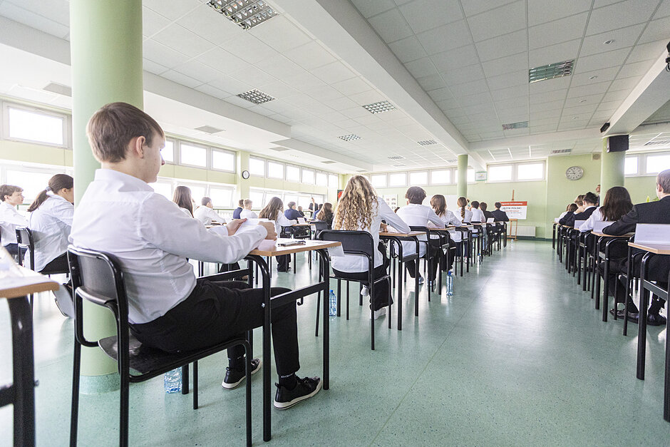 Uczniowie przy stolikach w trakcie egzaminu