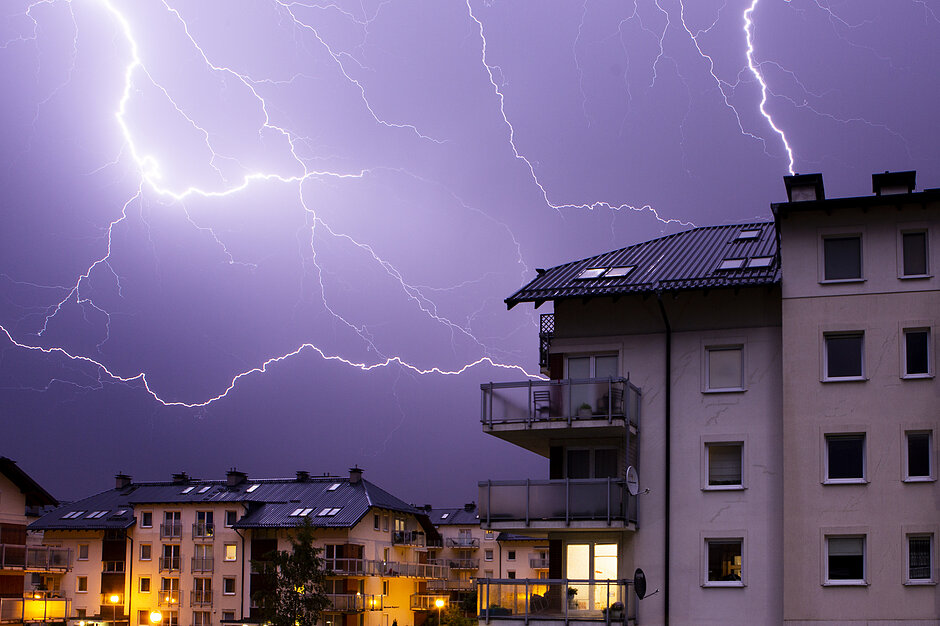 Błyskawice nad budynkami mieszkalnymi.