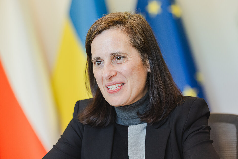 Zdjęcie uśmiechniętej kobiety w średnim wieku, w trakcie rozmowy