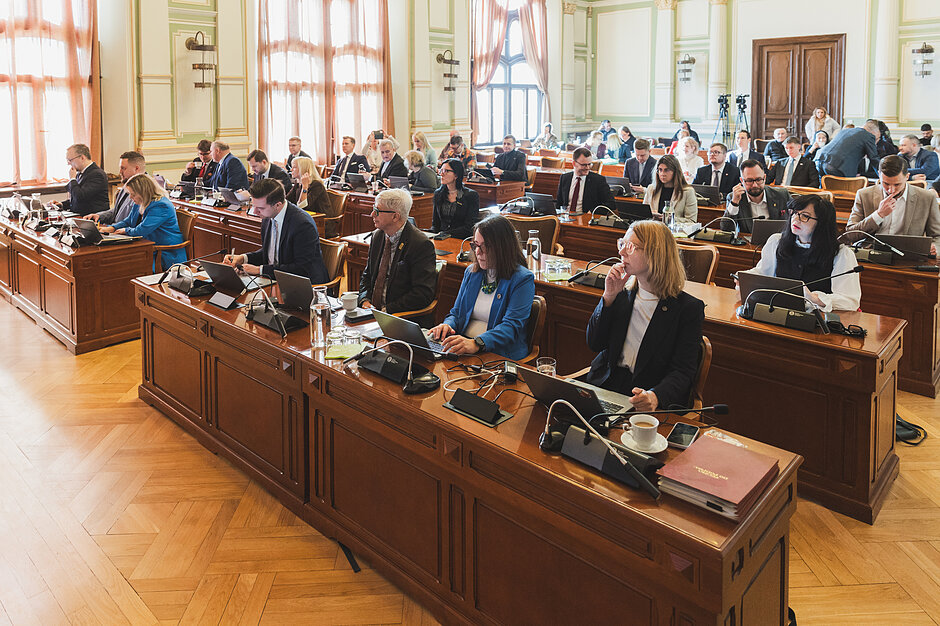 Sesja Rady Miasta Gdańska - radni siedzą na sali przy drewnianych stołach