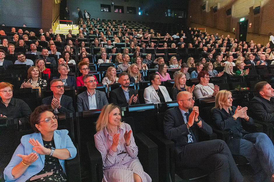 na zdjęciu widownia wypełniona kilkuset osobami
