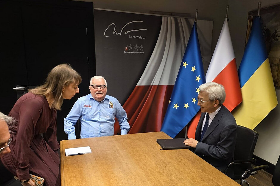 Dwaj mężczyźni przy stole, plus tłumaczka