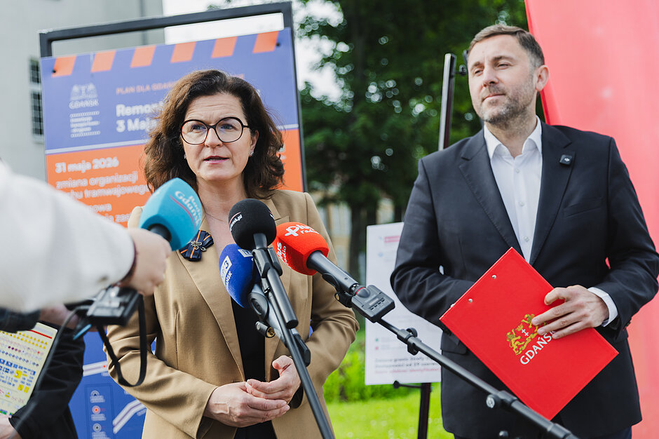 na zdjęciu prezydent Aleksandra Dulkiewicz i jej zastępca piotr borawski stoją przy mikrofonach dziennikarskich