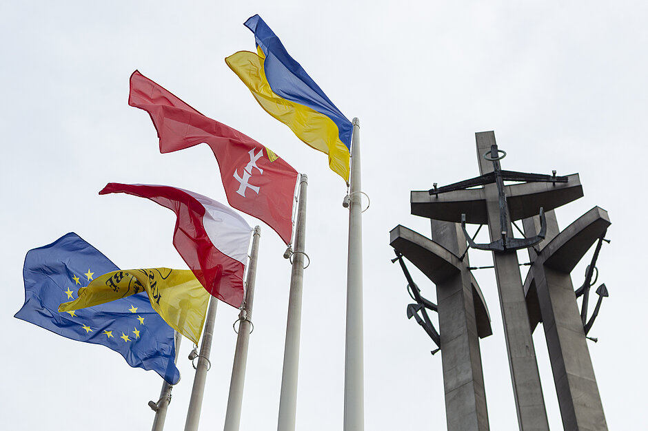 Ukraińska flaga wisi w Gdańsku obok innych flag i pomnika przy Stoczni