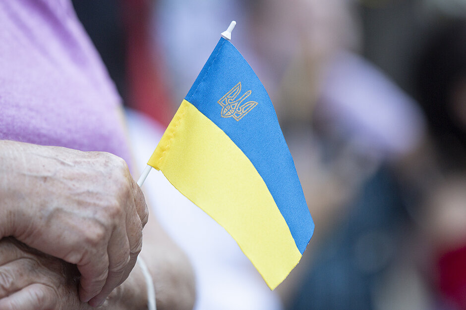 Kobieta trzyma w ręku ukraińską flagę. 