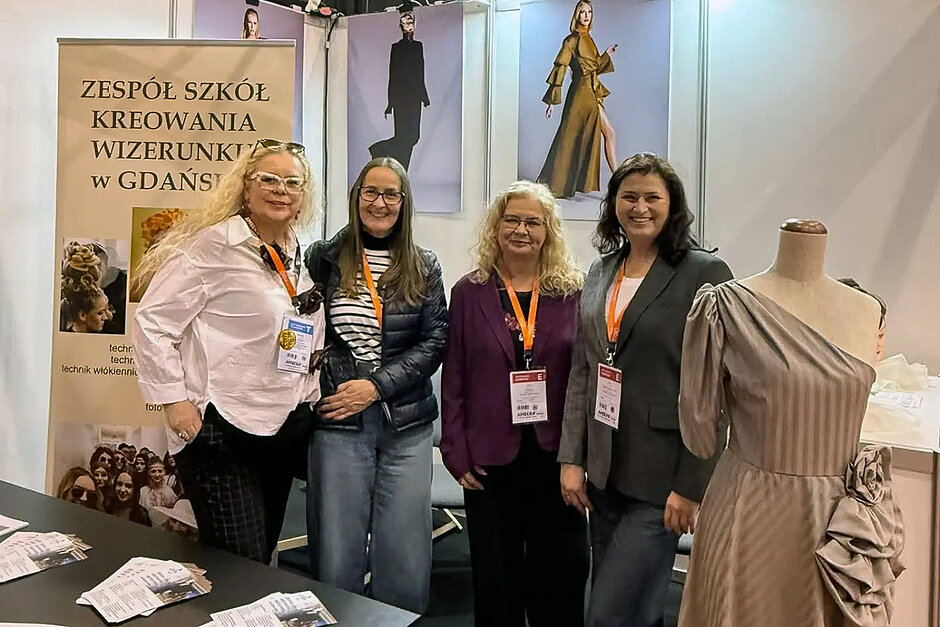 Stoisko Zespołu Szkół Kreowania Wizerunku w Gdańsku na targach Amberif Spring w AmberExpo. Na stoisku cztery kobiety pozują, uśmiechając się, do zdjęcia.