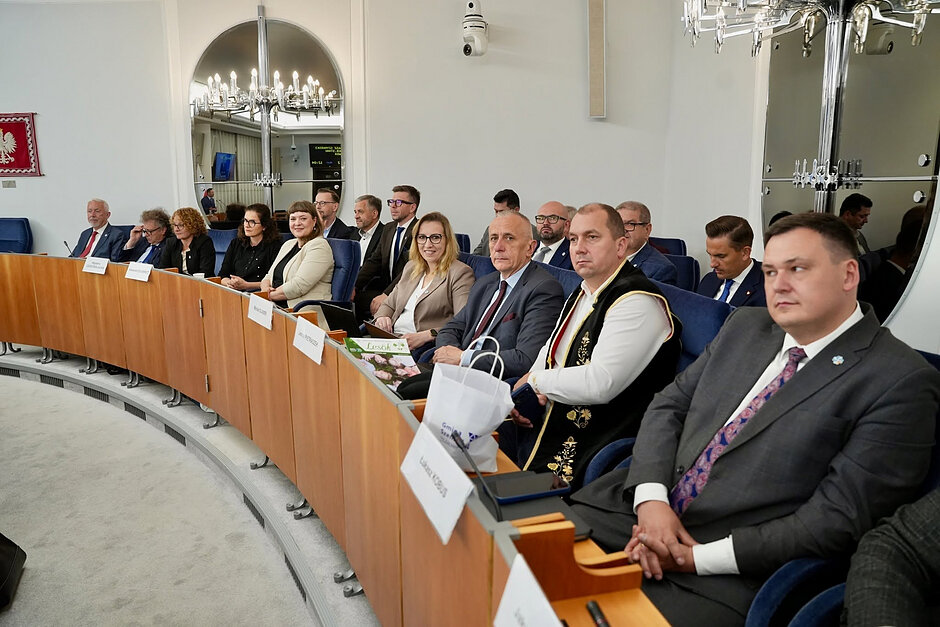 Dwa rzędy osób, które siedzą w sali senatu