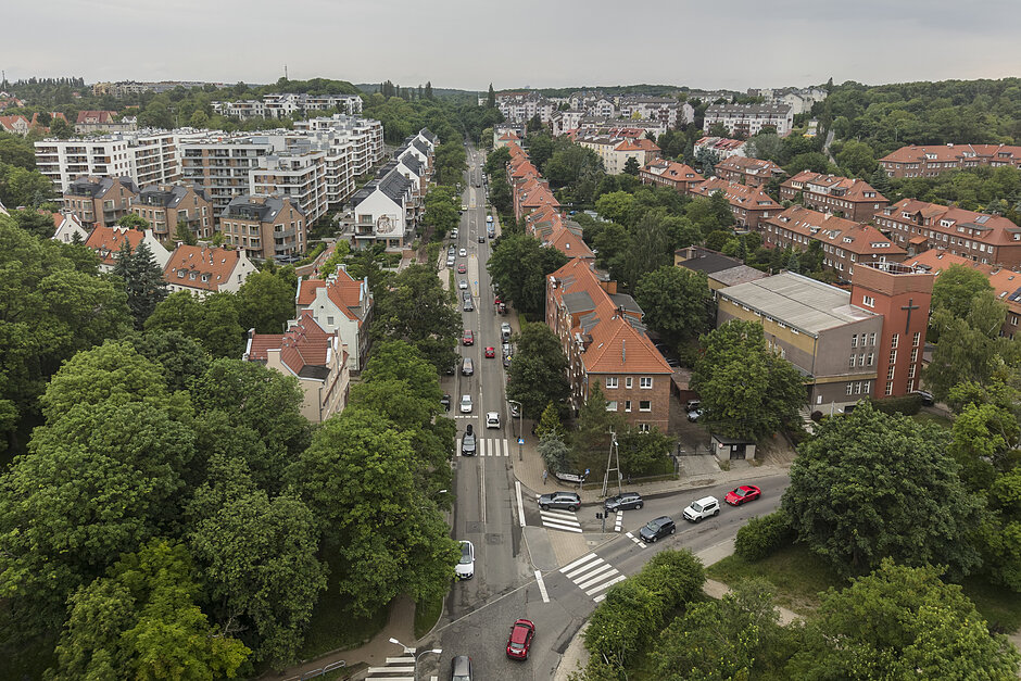 zdjęcie z drona, widać ulicę zabudową po obu stronach, jest też dużo zieleni