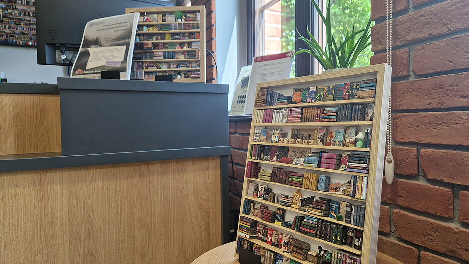 Dwie mini biblioteczki na biurkach biblioteki