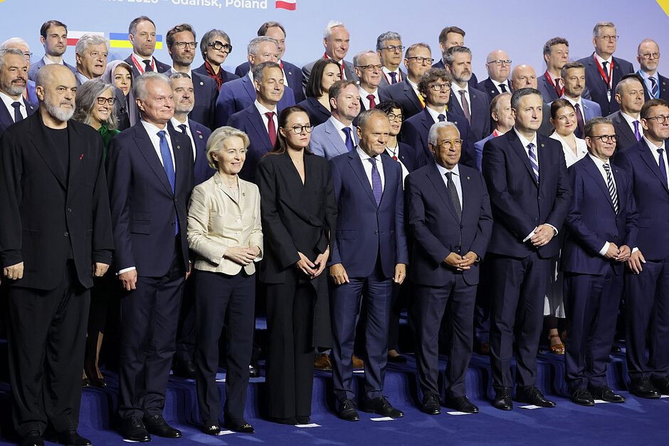 Zdjęcie dużej grupy osób pozujących do zdjęcia, pośrodku Donald Tusk