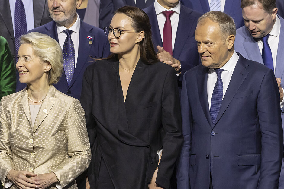Dwie kobiety i mężczyzna stoją na konferencji.