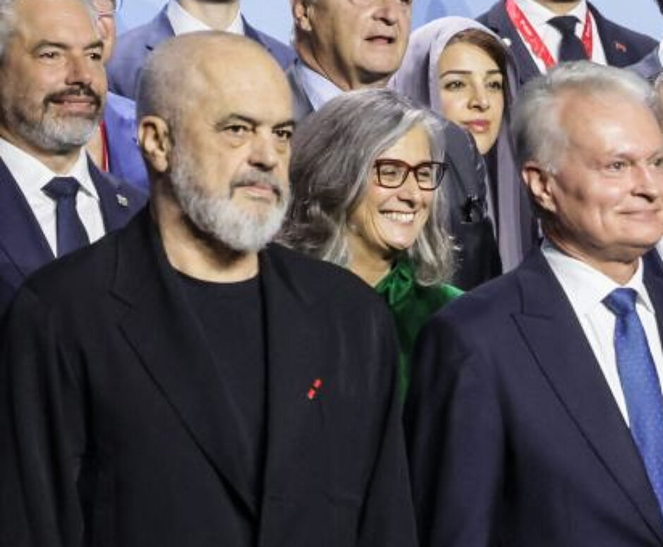 Ciasny kadr kilkoro ludzi stojących w tłumie na konferencji.
