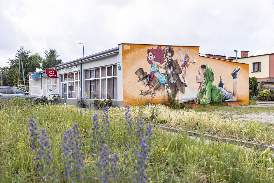 Mural z bajkowymi postaciami na budynku biblioteki.