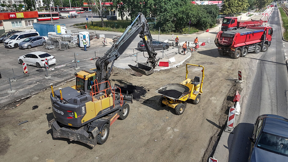 zdjęcie z drona, na pierwszym planie duża żółta koparka, widać rozkopaną jezdnię, w tle kilka samochodów