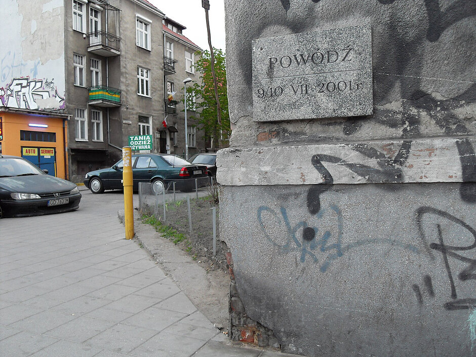 Tablica na elewacji budynku z napisem "powódź".