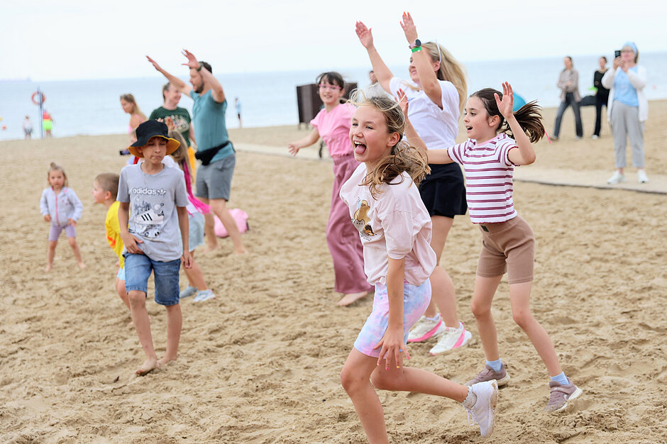 Zumba na plaży - roześmiane dzieci ćwiczą i tańczą