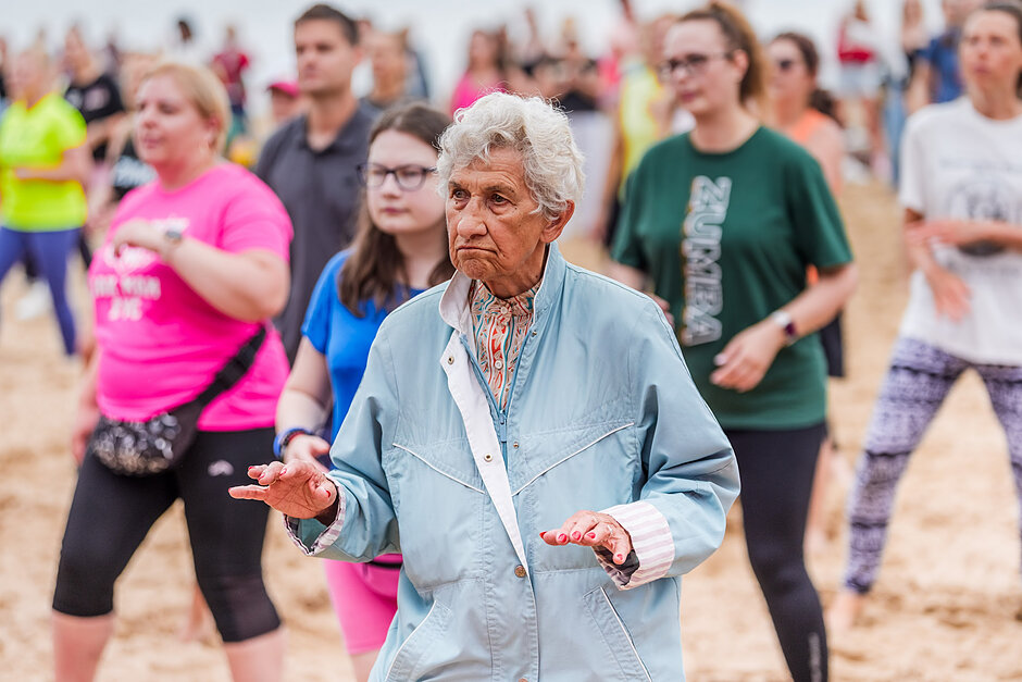 Seniorka ćwiczy Zumbę na plaży
