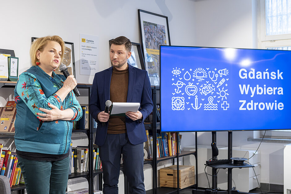 Gdańsk Wybiera Zdrowie - Katarzyna Bosacka mówi przez mikrofon. Obok niej stoi męczyzna. 