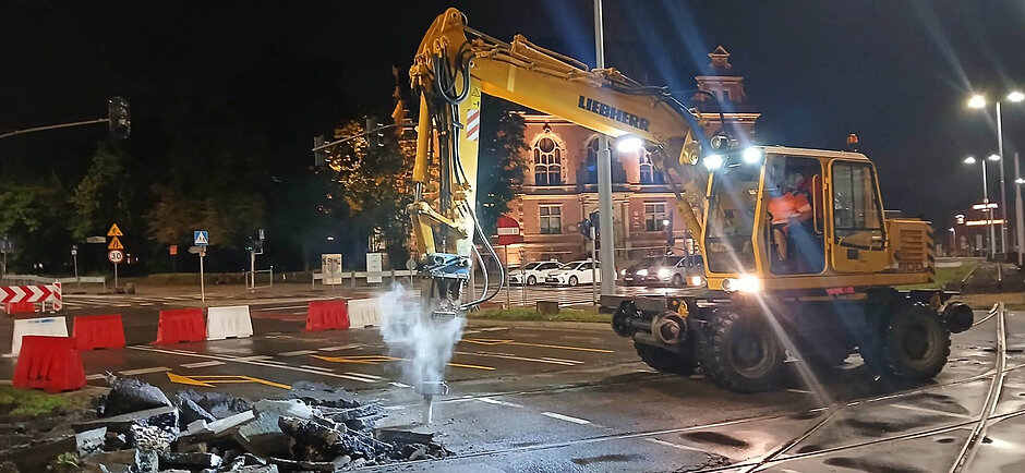 zdjęcie wykonano w nocy, widać koparkę rozbierającą nawierzchnię jezdni