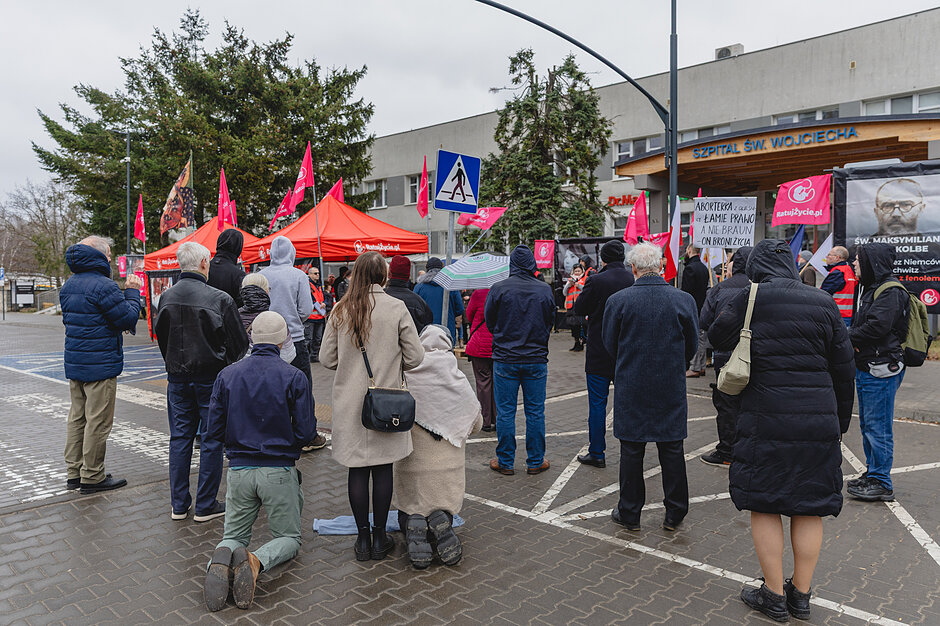 na zdjęciu kilka protestujących osób, w tym kilka osób klęczy 