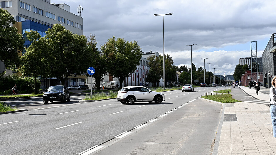 na zdjęciu kilkupasmowa jezdnia, widać kilka samochodów korzystających z tak zwanej nawrotki, zmieniających kierunek jazdy