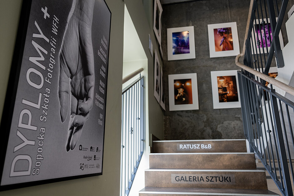 Plakat i wydruki fotografii na ścianach w galerii.