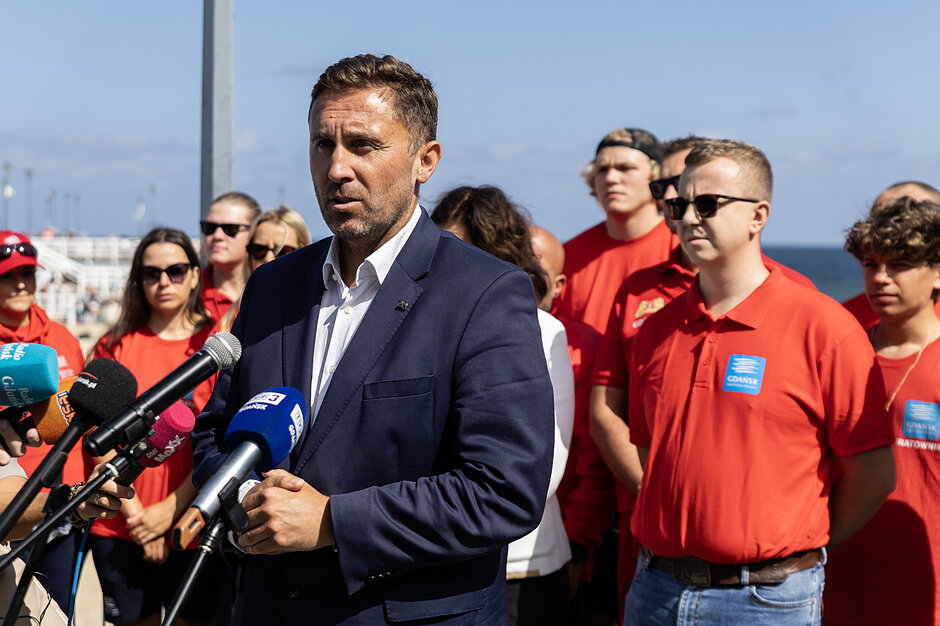 Mężczyzna w średnim wieku przemawia do mikrofonu