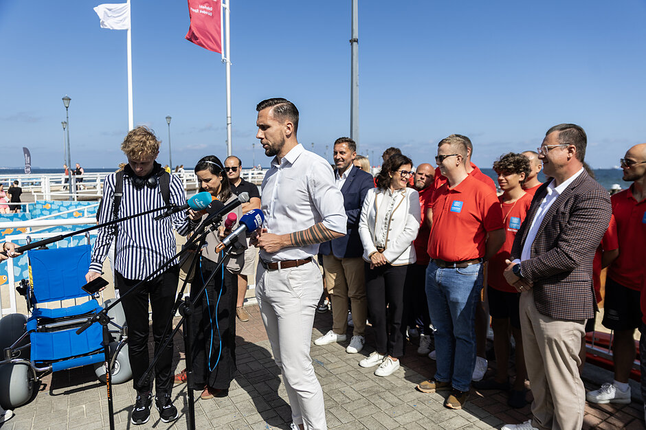 Szczupły wysoki mężczyzna w średnim wieku przemawia przez mikrofon