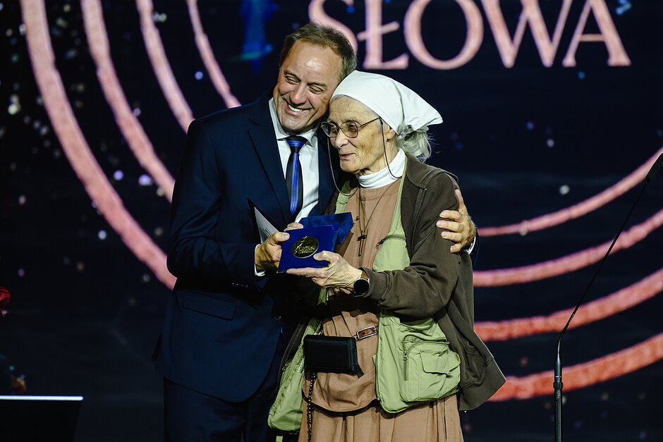 Siostra Chmielewska i marszałek Struk - stoją razem, uśmiechnięci, prezentują medal