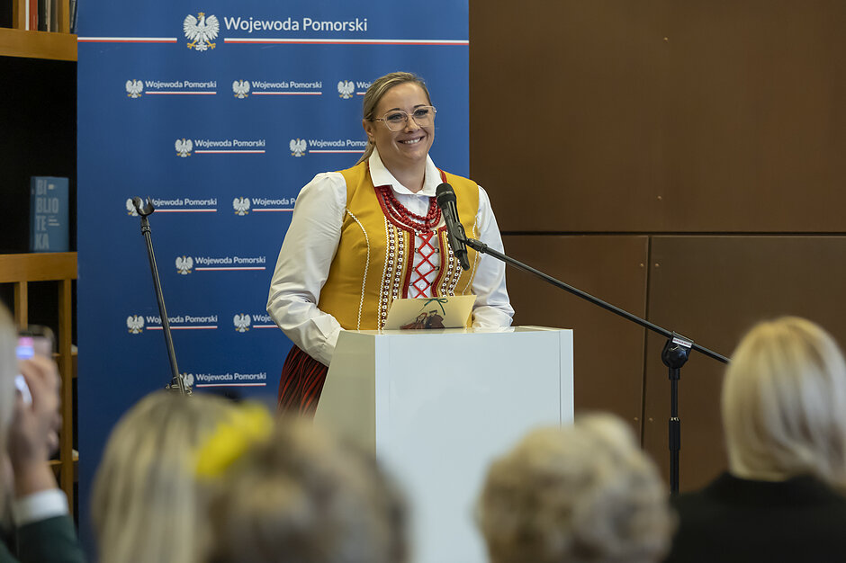 Polska Gotowa 2.0 - Rola Kobiet w Ochronie Ludności i Obronie Cywilnej. Łucja Wiśniewska przemawia przy mównicy w stroju ludowym