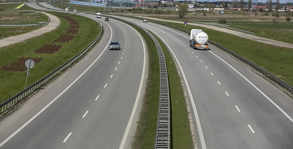 na zdjęciu autostrada, po dwa pasy ruchu w każdą stronę, widac kilka jadących samochodów