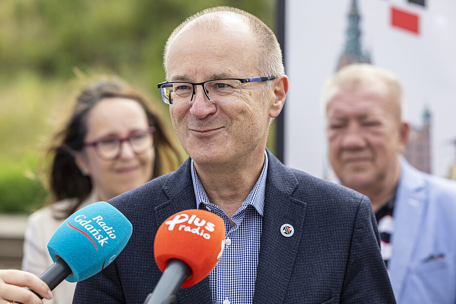 mężczyzna w średnim wieku mówi do mikrofonu