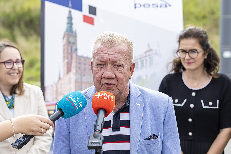 starszy mężczyzna mówi do mikrofonu