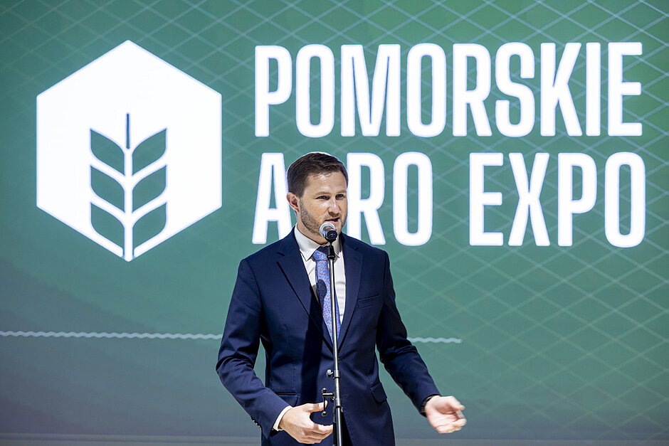 Mężczyzna przemawia do mikrofonu podczas konferencji prasowej.