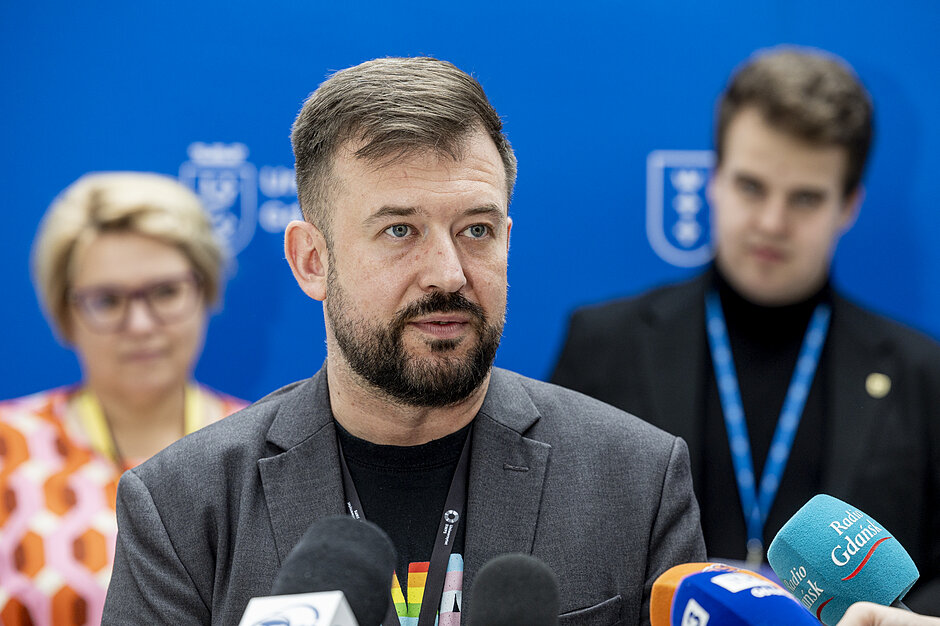 mężczyzna w średnim wieku mówi do mikrofonu