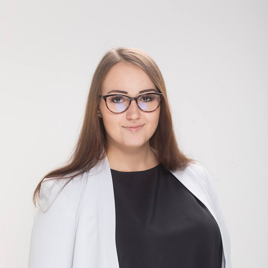 młoda kobieta w marynarce, lekko uśmiechnięta, ma rozpuszczone włosy