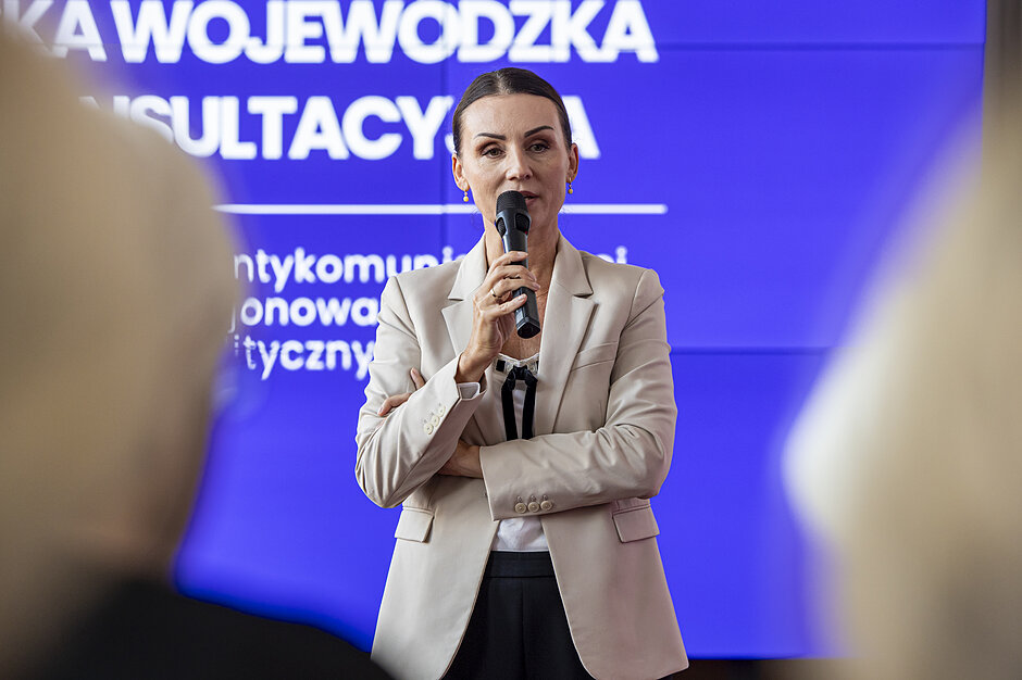 kobieta w średnim wieku przemawia do mikrofonu