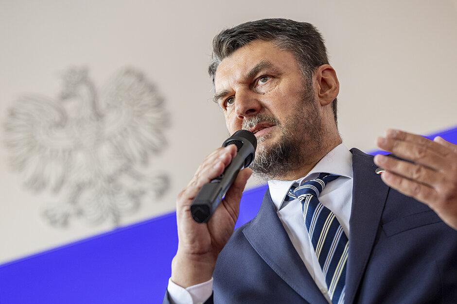 mężczyzna w średnim wieku mówi do mikrofonu