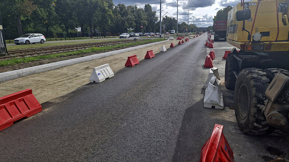 na zdjęciu po prawej nowy asfalt na jezdni, po lewej widać ulicę jeszcze bez nawierzchni