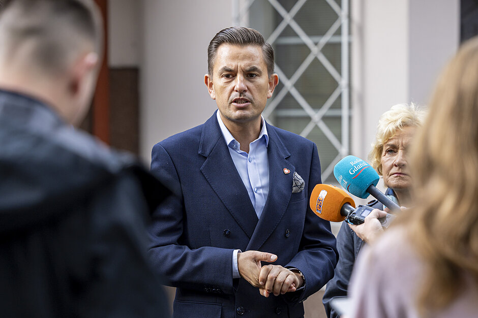 mężczyzna w średnim wieku mówi do mikrofonu