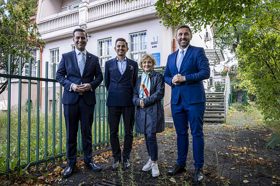 wymienione osoby pozują przed starą willą