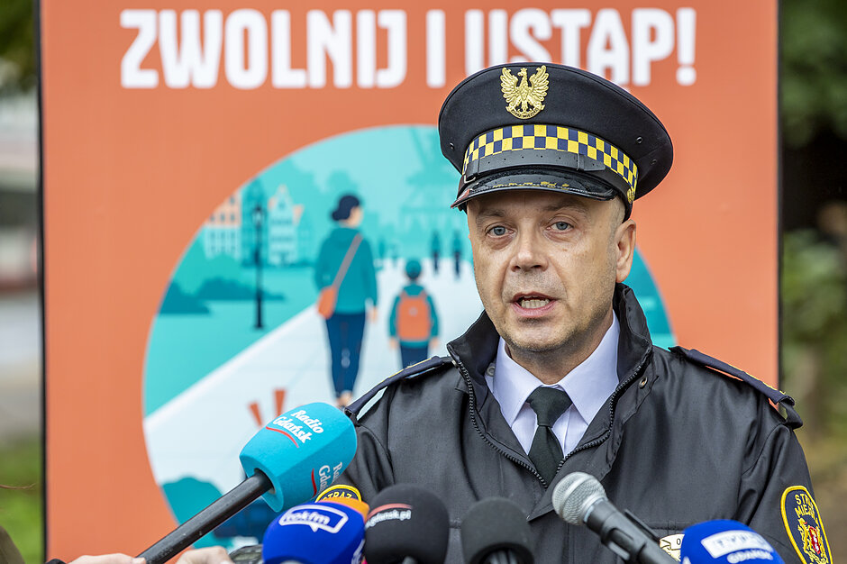 mężczyzna w mundurze mówi do mikrofonu