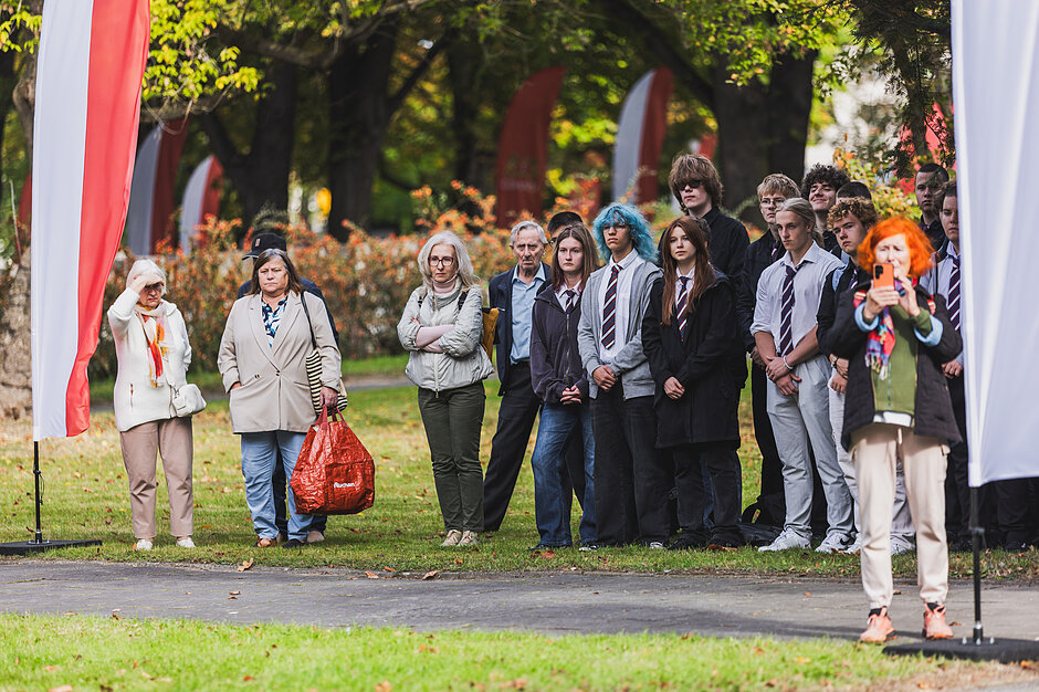 kilkunastoosobowa grupa młodych ludzi stoi w rzędzie