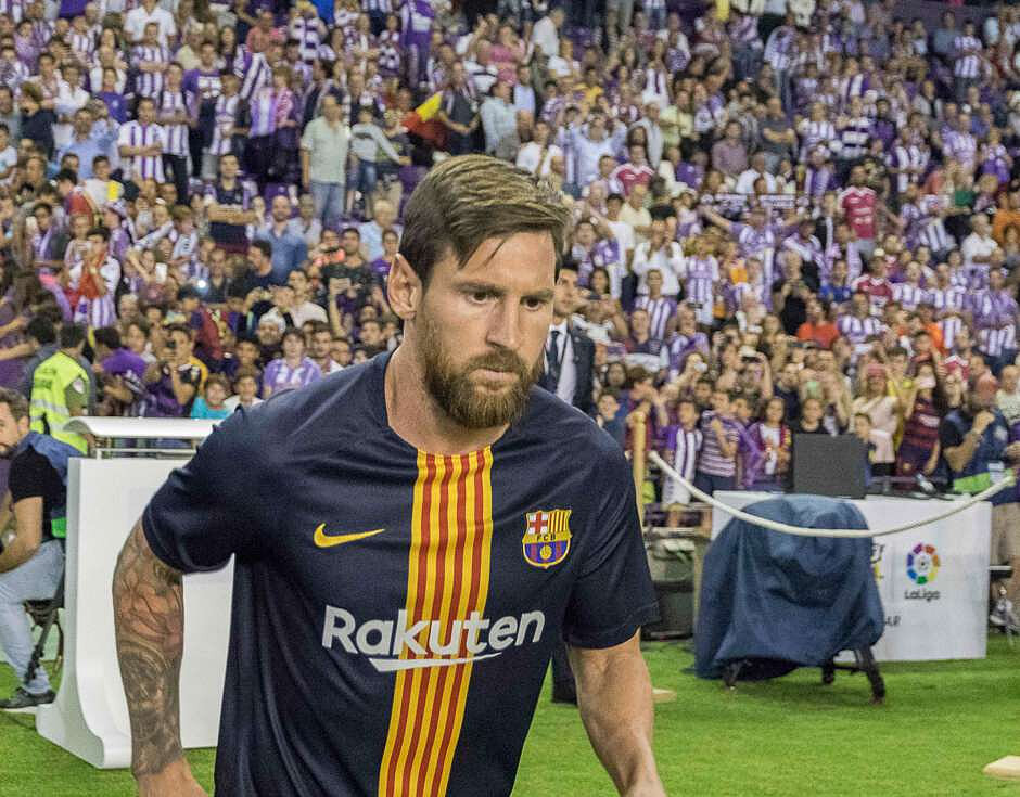 Leo Messi wchodzi na boisko, w tle trybuny z kibicami