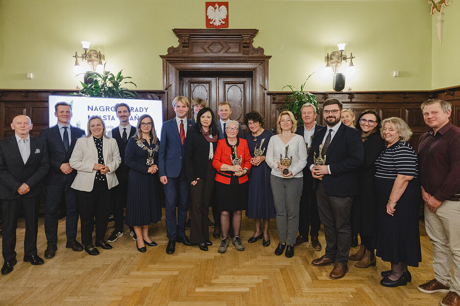 na zdjęciu pozuje kilkanaście osób, wszyscy stoją
